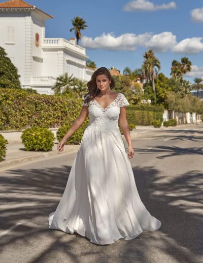 Frau im Brautkleid mit Spitze draußen