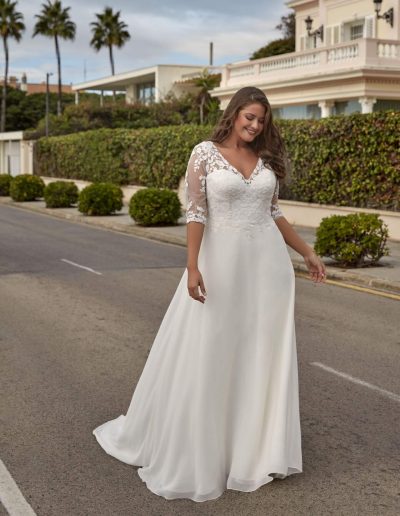 Frau im Brautkleid mit Spitze draußen
