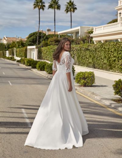 Frau im Brautkleid mit Spitze draußen