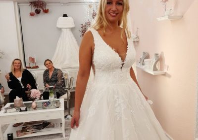 Braut im Spitzenkleid lächelt im Salon