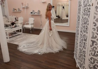 Braut trägt Kleid vor Spiegel