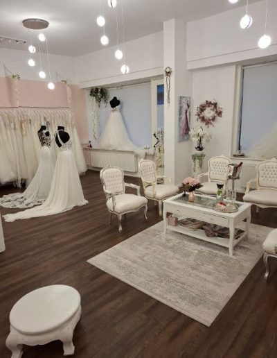Heller Sitzbereich mit Brautkleidern und Deko