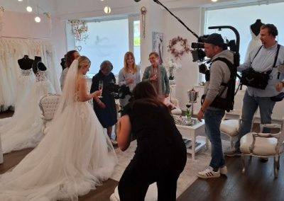 Kamerateam filmt Brautkleid-Anprobe im Geschäft