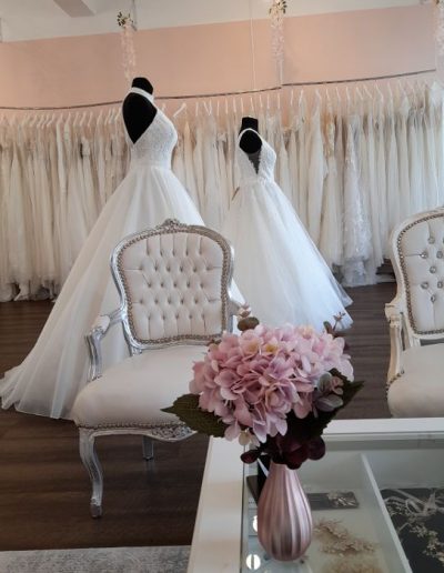 Schaufensterpuppen mit Spitzenkleidern im Salon
